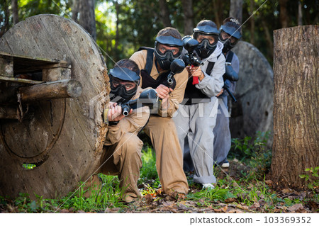 Paintball players aiming outdoors 103369352