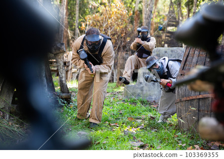 Paintball players shooting with guns Paintball players shooting with guns 103369355
