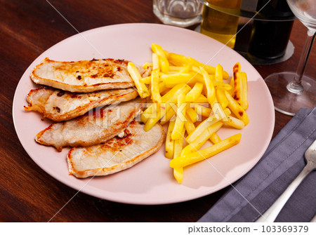 Close up of delicious baked pork with french fries Close up of delicious baked pork with french fries 103369379