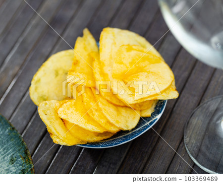 High angle view of fresh crunchy potato chips on table closeup 103369489