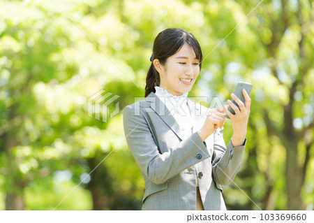 Photo of a woman using a smartphone 103369660