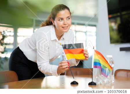 Unrecognizable girl sets up miniature LGBT and German flags before international talks Unrecognizable girl sets up miniature LGBT and German flags before international talks 103370016