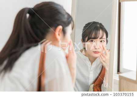 An Asian woman on her way home from work who suffers from dull skin, dark circles, and a tired face in the evening 103370155