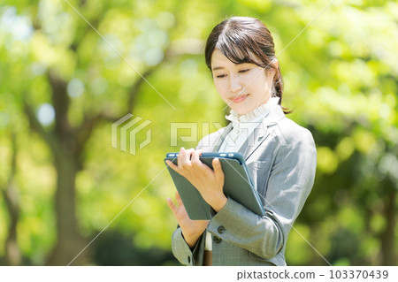 Photo of a woman standing in the greenery Photo of a woman standing in the greenery 103370439