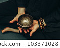Top view crossed two palms holding a copper singing bowl. Relaxation and meditation. Alternative medicine. Tibetan and Himalayan singing bowls. Make a sound 103371028