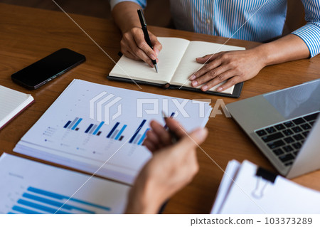 Close up of businessman is explaining business data and new project to partners and writing notes 103373289