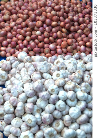 Texture or background of pile of common onions shallots and heaps of white garlic raw vegetables fresh organic food. Texture or background of pile of common onions shallots and heaps of white garlic raw vegetables fresh organic food. 103373330