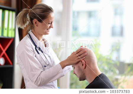 Positive dermatologist examines bald head man in clinic Positive dermatologist examines bald head man in clinic 103373783