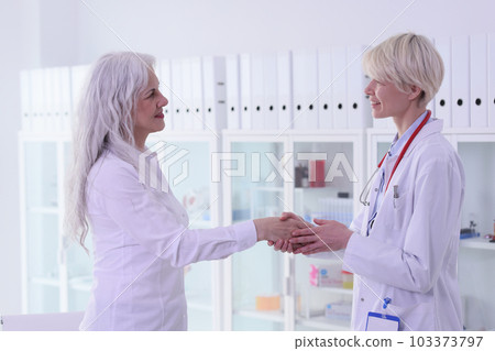 Blonde doctor takes old female patient with hand to calm Blonde doctor takes old female patient with hand to calm 103373797
