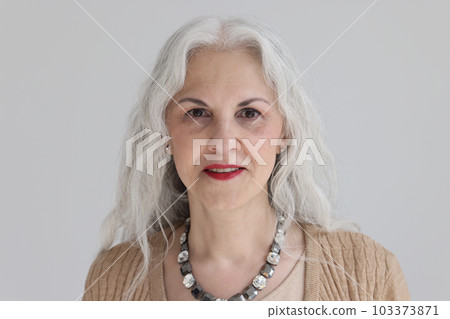 Attractive mature woman smiles lightly looking at camera 103373871