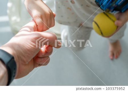 Little child's hand holding father's finger 103375952