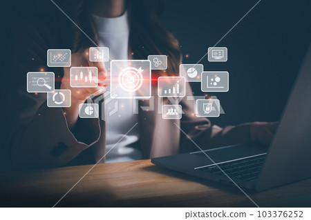 Businesswoman working on laptop and using a stylus pen for big data analytics and business intelligence with chart and graph icons. Goal acheiveement and success concept. Digital screen. 103376252