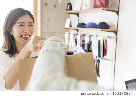 Young woman receiving goods after purchasing goods at the cash register Young woman receiving goods after purchasing goods at the cash register 103378854