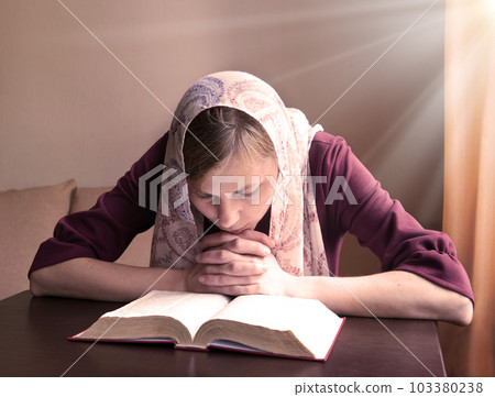 Girl reading a book by the window Girl reading a book by the window 103380238