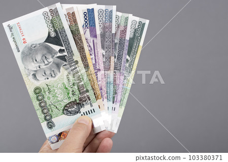 Cambodian money in the hand on a gray background 103380371