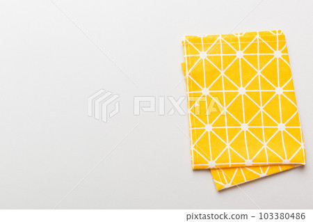 top view with yellow empty kitchen napkin isolated on table background. Folded cloth for mockup with copy space, Flat lay. Minimal style top view with yellow empty kitchen napkin isolated on table background. Folded cloth for mockup with copy space, Flat lay. Minimal style 103380486