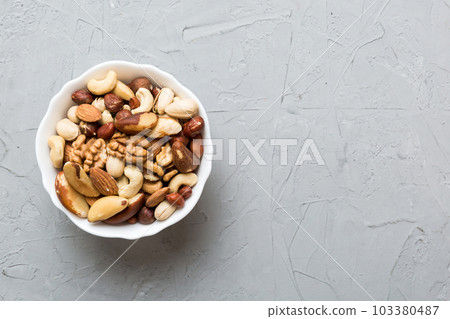 mixed nuts in bowl. Mix of various nuts on colored background. pistachios, cashews, walnuts, hazelnuts, peanuts and brazil nuts mixed nuts in bowl. Mix of various nuts on colored background. pistachios, cashews, walnuts, hazelnuts, peanuts and brazil nuts 103380487