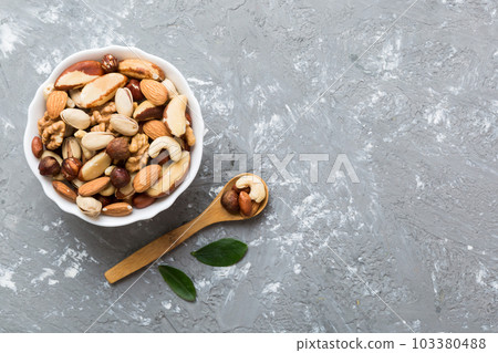mixed nuts in bowl. Mix of various nuts on colored background. pistachios, cashews, walnuts, hazelnuts, peanuts and brazil nuts mixed nuts in bowl. Mix of various nuts on colored background. pistachios, cashews, walnuts, hazelnuts, peanuts and brazil nuts 103380488