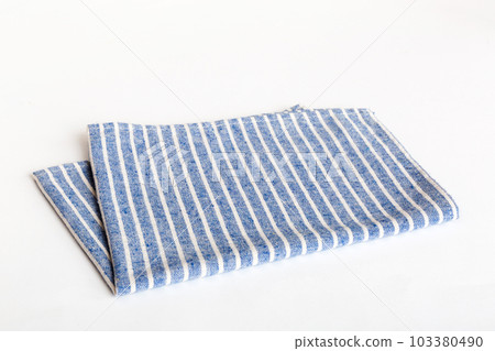 top view with blue kitchen napkin isolated on table background. Folded cloth for mockup with copy space, Flat lay. Minimal style top view with blue kitchen napkin isolated on table background. Folded cloth for mockup with copy space, Flat lay. Minimal style 103380490