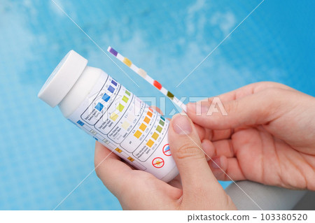 Analysis of the PH and chlorine of the water in a swimming pool in Summer. Check quality of water with test strip, comparing results Analysis of the PH and chlorine of the water in a swimming pool in Summer. Check quality of water with test strip, comparing results 103380520