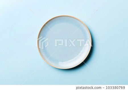 Top view of isolated of colored background empty round blue plate for food. Empty dish with space for your design 103380769