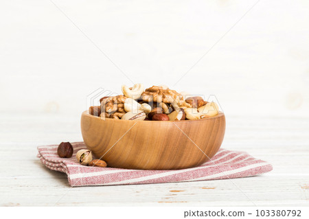 mixed nuts in bowl. Mix of various nuts on colored background. pistachios, cashews, walnuts, hazelnuts, peanuts and brazil nuts mixed nuts in bowl. Mix of various nuts on colored background. pistachios, cashews, walnuts, hazelnuts, peanuts and brazil nuts 103380792