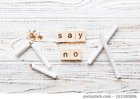 Cigarette And Wooden Blocks, Broken cigarette on table background, No Tobacco Day with hourglass, clock health concept. time to quit smoking Cigarette And Wooden Blocks, Broken cigarette on table background, No Tobacco Day with hourglass, clock health concept. time to quit smoking 103380806
