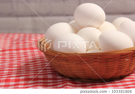 Basket of Farm Fresh Eggs on Red and White Checkered Fabric 103381808