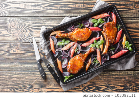 Healthy and tasty food baked pork chops with red onion, herbs and rhubarb close-up in a baking sheet. Horizontal top view Healthy and tasty food baked pork chops with red onion, herbs and rhubarb close-up in a baking sheet. Horizontal top view 103382111