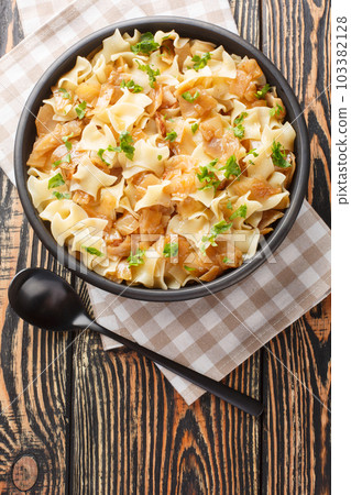 Krautfleckerl are a traditional Austrian food made out of noodles fleckerl pasta and caramelized cabbage closeup on the bowl. Vertical top view 103382128