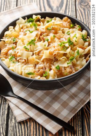 Krautfleckerl are a traditional Austrian food made out of noodles fleckerl pasta and caramelized cabbage closeup on the bowl. Vertical 103382134