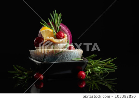 Herring fillet in oil with lemon, onion, rosemary, and cranberries. 103382850