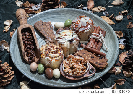 Bakery, Stick cookies, Walnuts, Roasted coffee beans and Colored eggs with Pine cones on Ceramic plate. 103383070