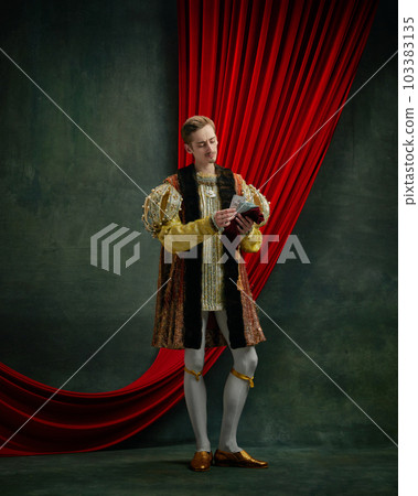 Portrait of young man standing and counting paper money against dark green, vintage background Portrait of young man standing and counting paper money against dark green, vintage background 103383135