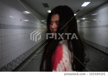 Scary woman in white dress with bloodstain after murder, Halloween concept Scary woman in white dress with bloodstain after murder, Halloween concept 103384101