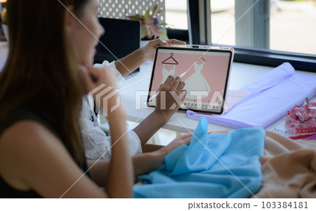 Happy female dressmaker working in workshop studio 103384181