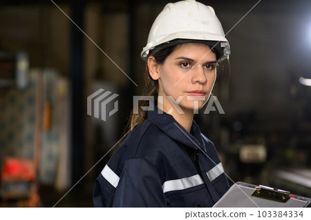 Confident female technician engineer worker checking and inspecting machine  103384334