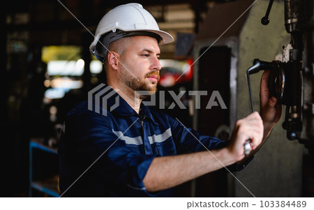 Professional male technician checking and repairing machinery Professional male technician checking and repairing machinery 103384489