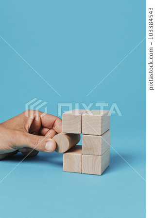 man plays with toy blocks 103384543