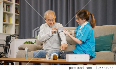 Young caregiver doctor examining senior patient using blood pressure gauge 103384972