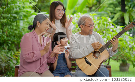 Family having activities together at home, Grandfather playing guitar happily 103385032