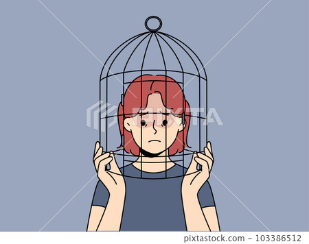 Unhappy teen girl with head in birdcage 103386512