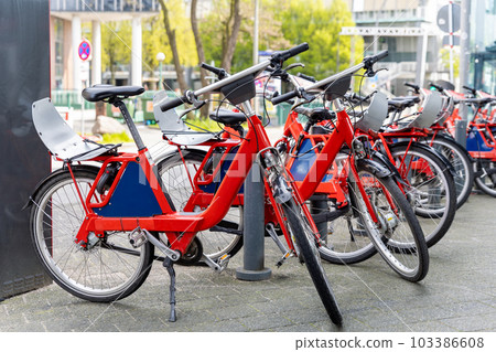 Closeup view many red city bikes parked in row at german Hamburg city street rental parking sharing station or sale. Healthy ecology urban transportation. Sport environmental transport infrastructure 103386608
