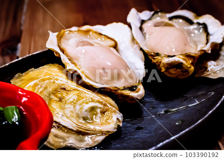 豐滿的牡蠣菜餚放在黑色盤子裡 豐滿的牡蠣菜餚放在黑色盤子裡 103390192