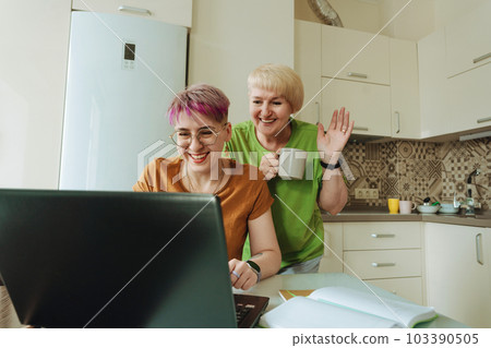 Mother and daughter use modern gadgets, laptop for online communication 103390505