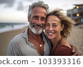 Middle age cuddling couple enjoying time on beach 103393316