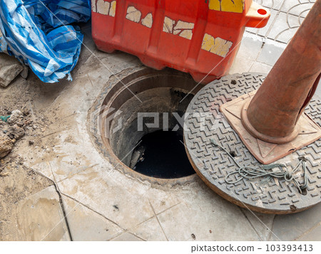 The manhole cover was opened for maintenance time. 103393413