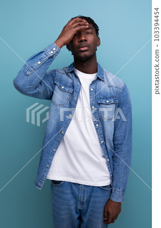 upset african man with curly hair in a casual look 103394454