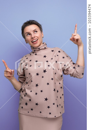 positive energetic young caucasian dark-haired lady in a short-haired skirt and blouse gesticulates 103394474
