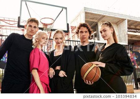 Boys and girls teenagers play basketball together, spend time, have fun in the city sports park. 103394834